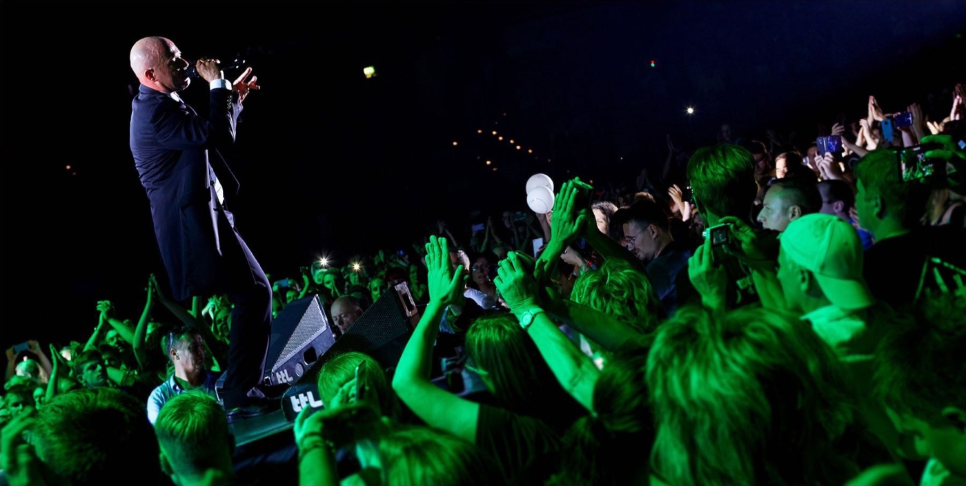 Der Sänger von Unheilig während eines Konzertes. Das Publikum in grünes Licht getaucht