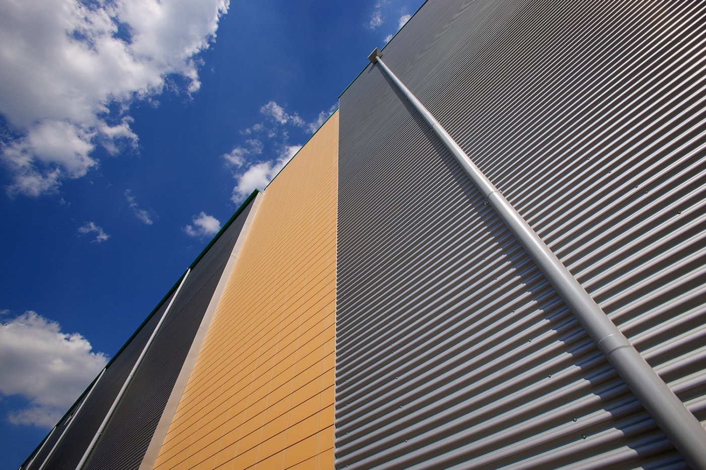 Schrägaufnahme einer Produktionsstätte für Chips mit Blick zum blauen Himmel Graue und Orangen Fassade