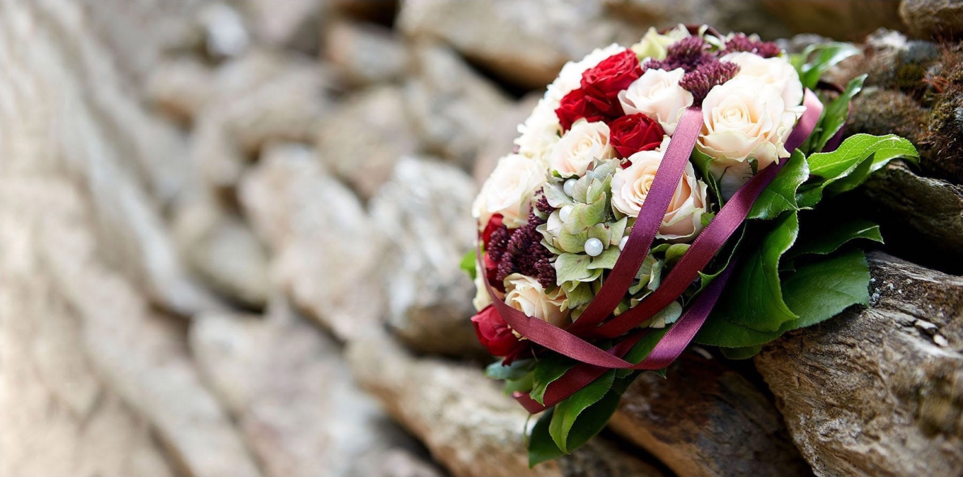 Schöner bunter Brautstrauss an einer Natursteinwand