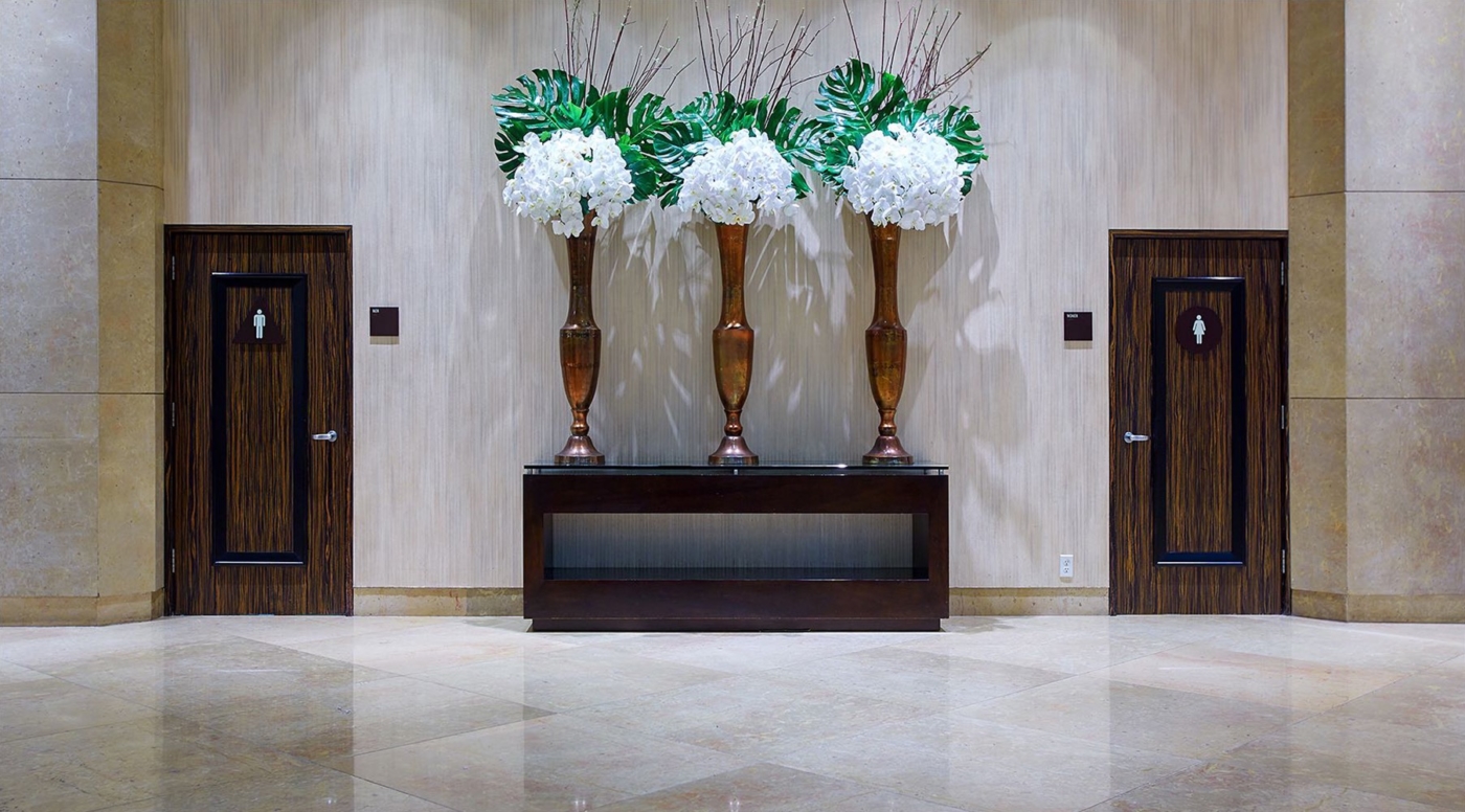Lobby eines Hotels in New York City mit Blick zu den Toiletten und große Blumenarrangements im der Bildmitte