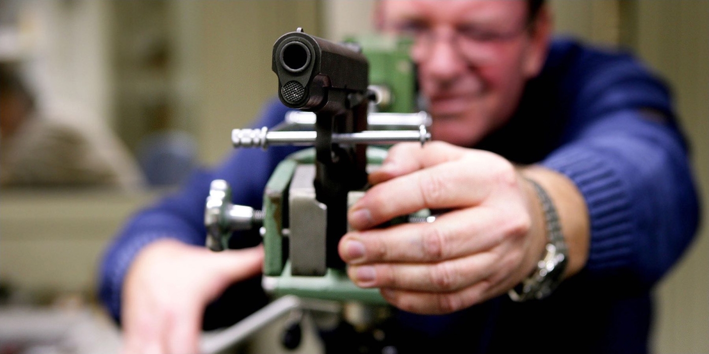 Kriminalbeamter, im Hintergrund unscharf, beim Test einer Pistole