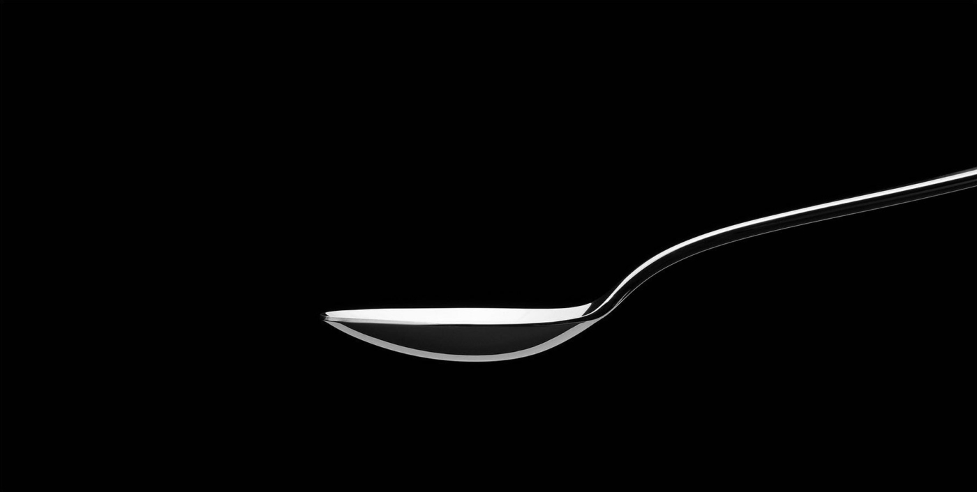 Designstudie eines edlen silbernen Löffels vor schwarzem Hintergrund